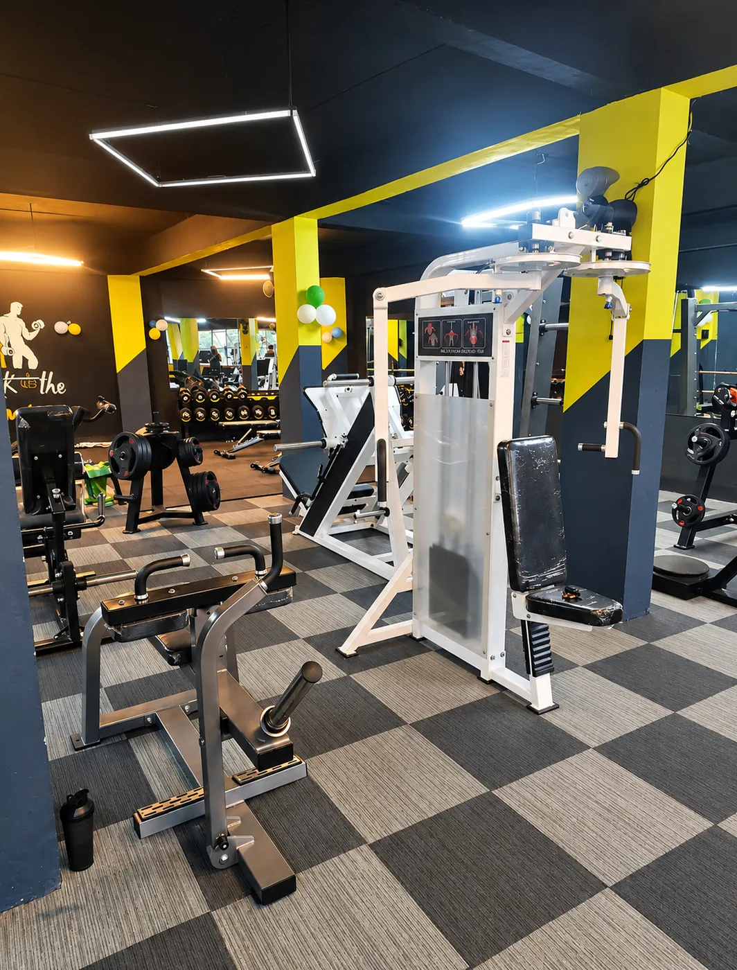 Selectorised strength machines beside yellow pillars at the My Health Fitness Industry gym in Ayoor