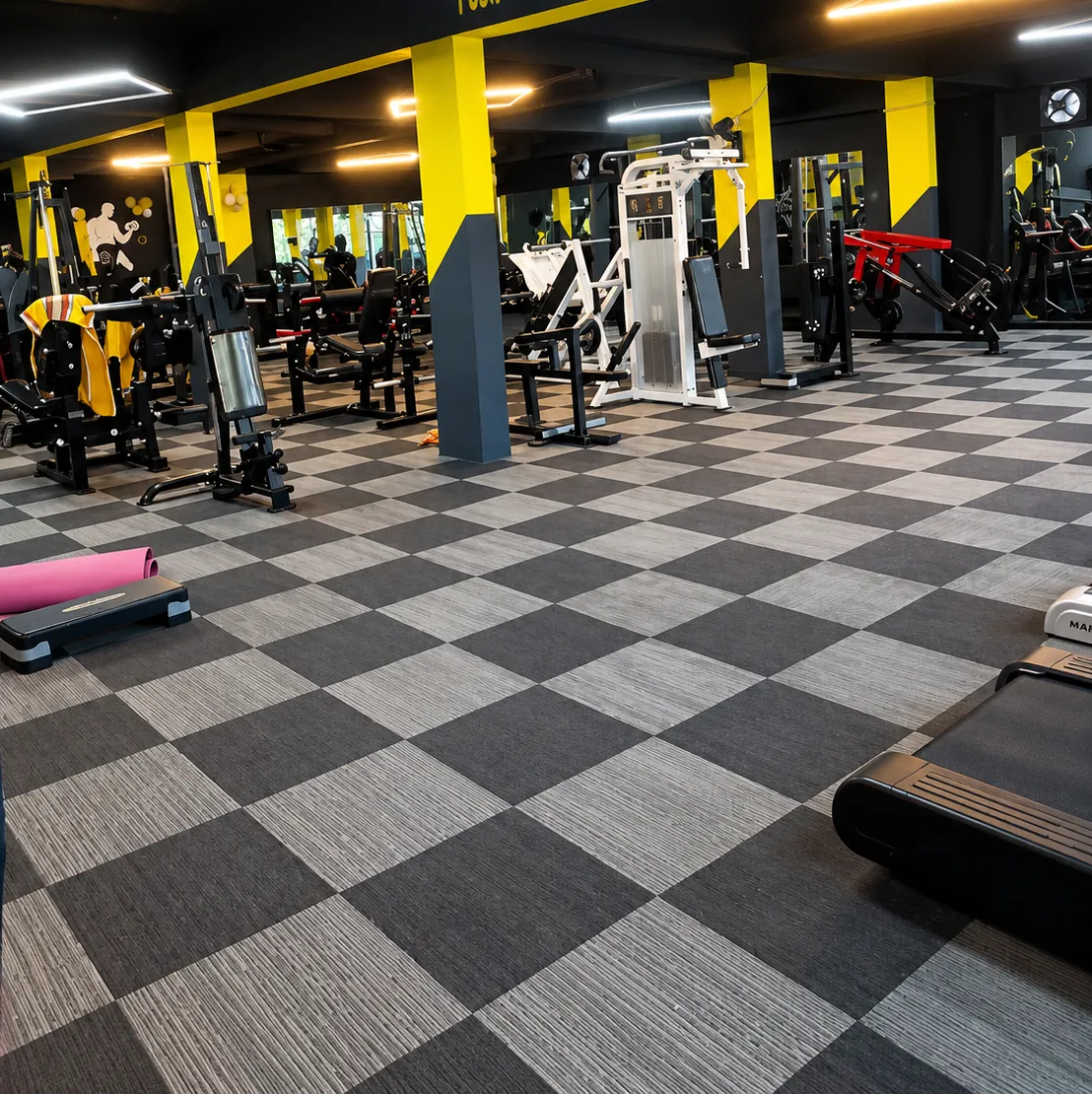 Strength machines on the checkered training floor of the Ayoor gym