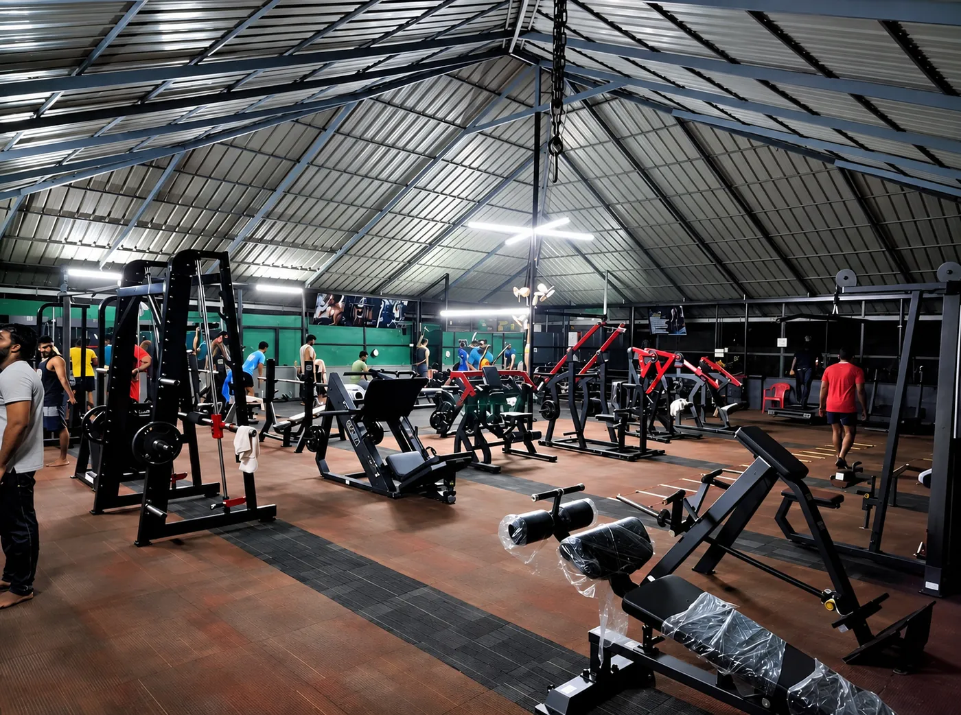 Members training among plate-loaded and cable machines at the Kottarakkara gym
